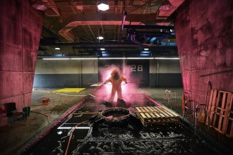 This picture shows a man in a hazmat suit cleaning pallets