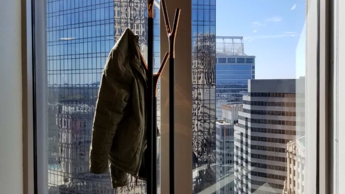 A freestanding coat rack near a window