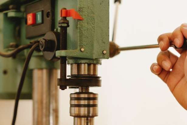 Drill press with hand of operator