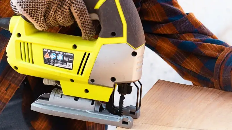 Woodworker using yellow jigsaw