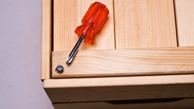 Red handled screwdriver on wooden box