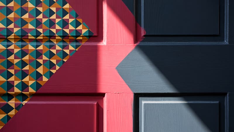 A creative front door mural showcasing the harmonious interplay between a geometric pattern and the door's solid color, inspiring creative color concepts.